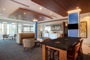 a lobby at a hospital with a table and chairs at Holiday Inn Express & Suites - Beloit, an IHG Hotel in Beloit