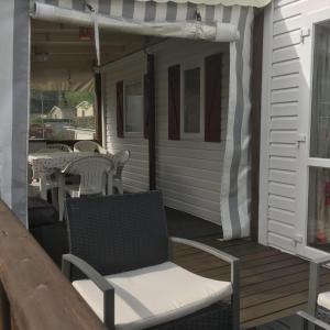 een patio met een stoel en een tafel op een veranda bij 3 Bedroom Holiday Home at Siblu in Pont-Aven