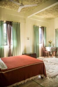 a bedroom with a red bed and a table and chairs at Posada El Castillo xilitla in Xilitla