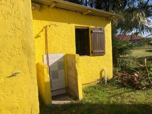 una casa amarilla con puerta y ventana en Casefo, en Aguas Dulces