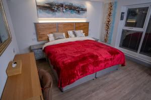 a bedroom with a large bed with a red blanket at Magnolia House, Rye in Rye
