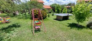 a swing set in the grass in a yard at Ayres Serranos in Merlo +4 photos