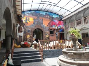 a building with stairs and a mural on the wall at Pariwana Hostel Cusco in Cusco