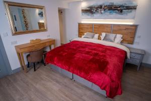 a bedroom with a bed with a red blanket at Magnolia House, Rye in Rye