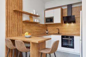 eine Küche mit einem Holztisch und Stühlen in der Unterkunft Bjelica Rental Apartments - Nela Apartment in Tivat
