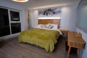 a bedroom with a large bed with a green blanket at Magnolia House, Rye in Rye