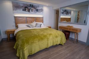 a bedroom with a large bed with a green blanket at Magnolia House, Rye in Rye
