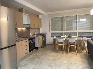 a kitchen with a table and chairs in a kitchen at UIM Mediterraneo PB Felipe 2 Wifi in Puerto de Sagunto