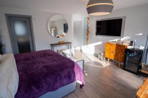 a bedroom with a purple bed and a mirror at Magnolia House, Rye in Rye