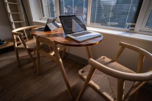 a wooden table with a laptop on it next to a window at Magnolia House, Rye in Rye