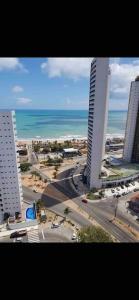 a view of a city with the ocean and buildings at Ilusion flat Ponta Negra in Natal