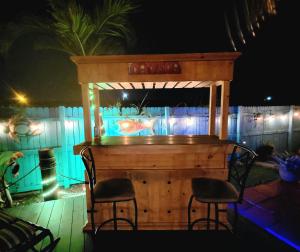 a bar with two chairs in front of a fence at Hidden Oasis in West Palm Beach