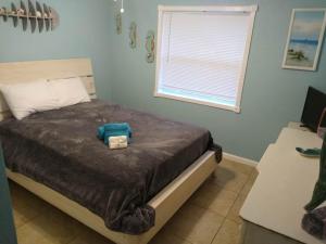 a bedroom with a bed with a blue stuffed animal on it at Hidden Oasis in West Palm Beach