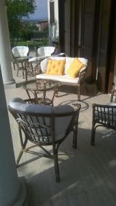 eine Terrasse mit einem Tisch, Stühlen und einem Sofa in der Unterkunft B&B Villa Adriano in Cavaion Veronese