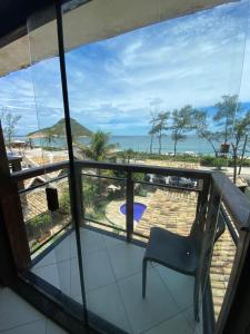 a balcony with a chair and a view of the beach at Pontal Hostel - Pousada Pontal RJ in Rio de Janeiro