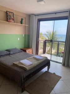 a bedroom with a bed with a view of the ocean at Pontal Hostel - Pousada Pontal RJ in Rio de Janeiro