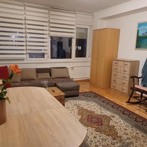 een woonkamer met een bank en een tafel bij Brand New - Central Apartments in Sarajevo