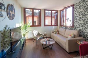 ein Wohnzimmer mit einem Sofa und einem TV in der Unterkunft Arista Huesca in Huesca