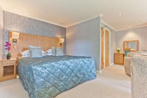 a bedroom with a large bed with a blue comforter at Ambleside Salutation Hotel & Spa, World Hotel Distinctive in Ambleside