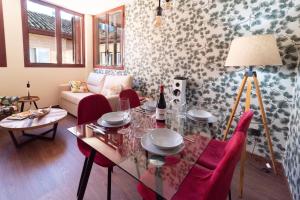 a living room with a glass table and red chairs at Arista Huesca in Huesca