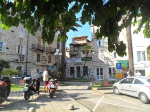 a man standing next to two motorcycles in a parking lot at Guest House Leon in Korčula