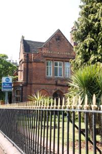 a black fence in front of a brick building at Best Western Plough and Harrow Hotel in Birmingham