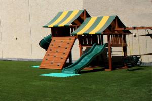 um parque infantil com um escorrega e uma estrutura de jogos em Le Jazz Hotel em Kuwait