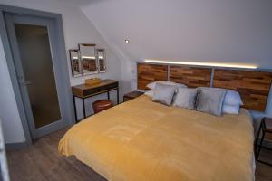 a bedroom with a large yellow bed with a wooden headboard at Magnolia House, Rye in Rye