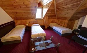 ピョートルクフ・トルィブナルスキにあるSenatorのベッド2台と窓が備わる屋根裏部屋です。