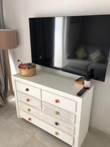 a white dresser with a television on top of it at StudioMarine in Le Diamant