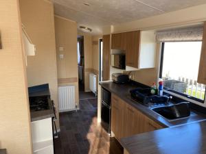 a kitchen with a sink and a counter top at 2 and 3 Bedroom caravans with Hot Tubs at tattershall in Tattershall