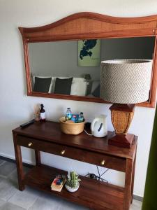 a wooden table with a mirror and a lamp on it at StudioMarine in Le Diamant