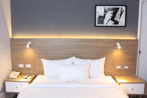 um quarto de hotel com uma cama e um telefone em Habitat Hotel em Lima