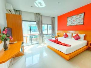 a bedroom with a bed with an orange wall at PJ Patong Resortel in Patong Beach
