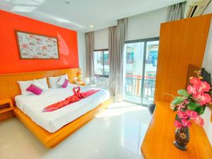 a bedroom with a bed with a red wall at PJ Patong Resortel in Patong Beach
