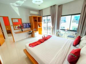 a bedroom with a large white bed with red pillows at PJ Patong Resortel in Patong Beach