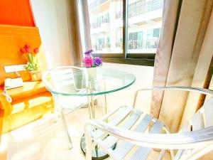 a glass table and chairs in a room with a window at PJ Patong Resortel in Patong Beach
