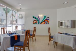 a dining room with two tables and chairs and a painting at Hotel Felix in Lorca