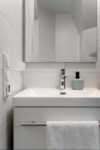 a white bathroom with a sink and a mirror at A Place To Stay Stavanger, apartment 2 in Stavanger