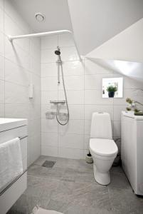 a white bathroom with a shower and a toilet at A Place To Stay Stavanger, apartment 2 in Stavanger
