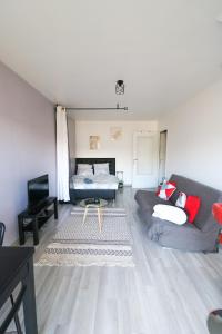 a living room with a couch and a bed at Studio cosy in Cergy