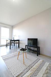 a living room with a table and a tv at Studio cosy in Cergy