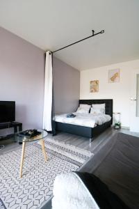 a bedroom with a bed and a coffee table at Studio cosy in Cergy