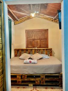 1 dormitorio con 1 cama con cabecero de madera en Bambito´s Café & Hostel, en Cerro Punta