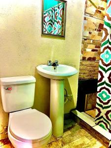 y baño con aseo y lavamanos. en Bambito´s Café & Hostel en Cerro Punta