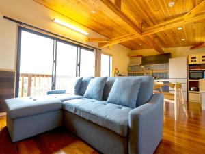 ein Wohnzimmer mit einer blauen Couch in einer Küche in der Unterkunft Tenkyu Inn - Vacation STAY 07349v in Kachabaru