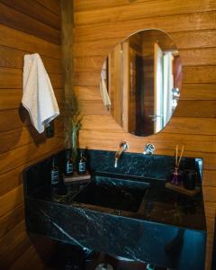 a bathroom with a black sink and a mirror at Nature Moreré - Bangalôs com vista para o Mar in Moreré