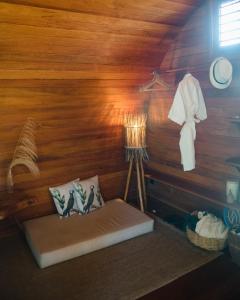 Ce lit se trouve dans un dortoir doté d'un mur en bois. dans l'établissement Nature Moreré - Bangalôs com vista para o Mar, à Moreré