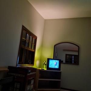 sala de estar con TV y espejo en Beira Mar Hostel, en Florianópolis