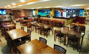 um restaurante com mesas e cadeiras de madeira e um bar em Resort GoldenLake em Arraial do Cabo em Arraial do Cabo
